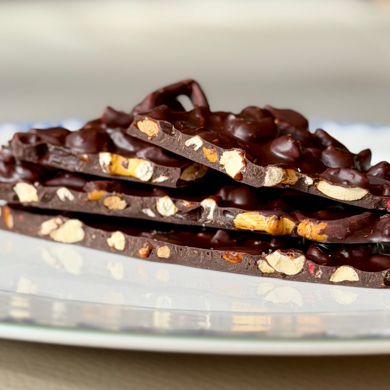 Dark chocolate bark with nuts on a white plate