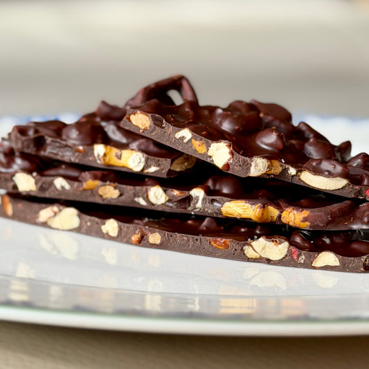 Dark chocolate bark with nuts on a white plate