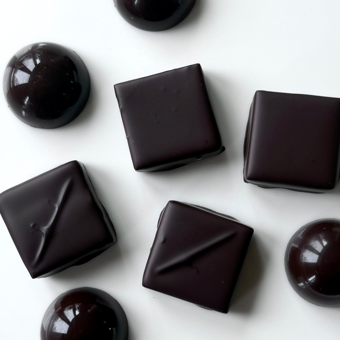 Dark chocolate candies on a white background