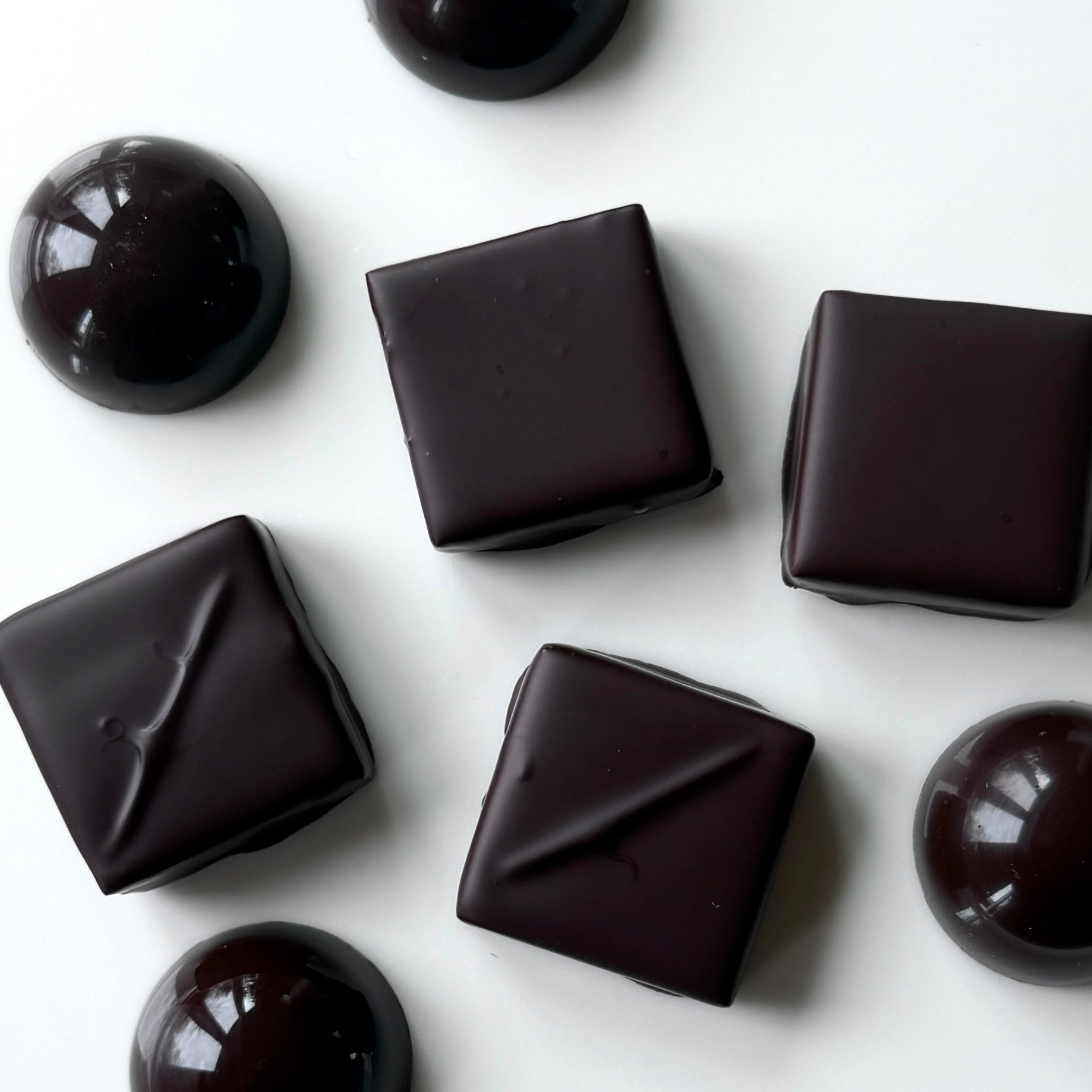 Dark chocolate candies on a white background