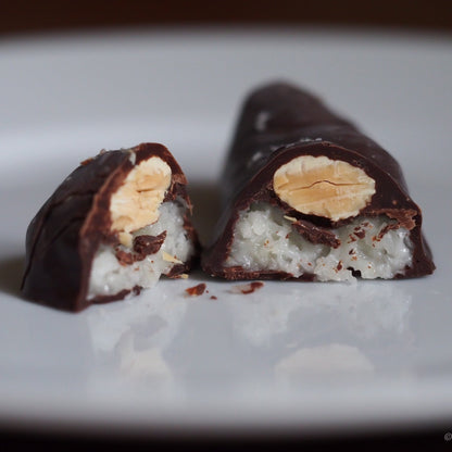 Chocolate-covered treat with a visible filling on a white plate