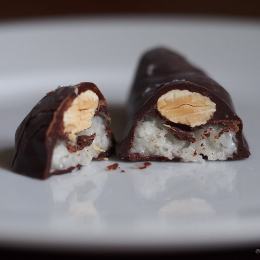 Chocolate-covered treat with a visible filling on a white plate