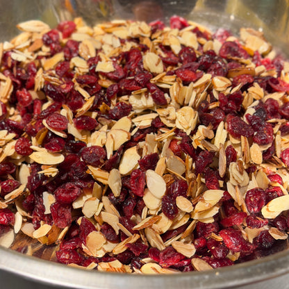 Candied slice toasted almonds mixed with dried cranberries in steel bowl