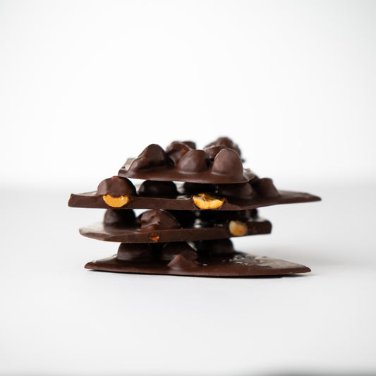 Chocolate structure with embedded nuts on a white background