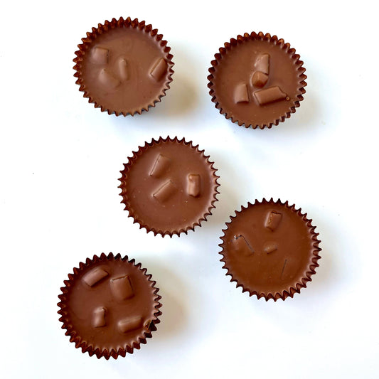 Five chocolate hazelnut cups with a white background 