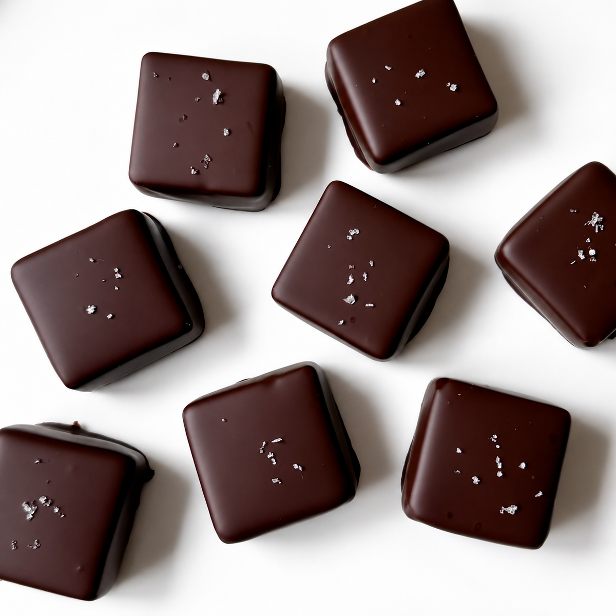 Dark Chocolate Squares topped with fleur de sel on white background