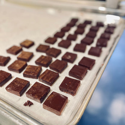 Chocolate squares on a white surface with a blurred background