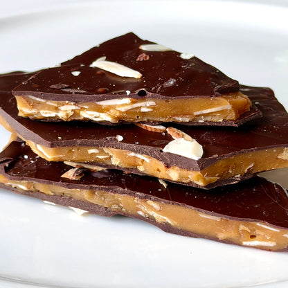 Dark chocolate toffee pieces on a white plate