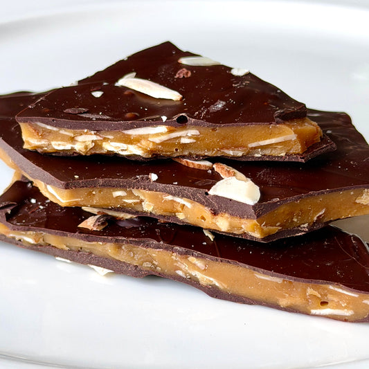 Dark chocolate toffee pieces on a white plate