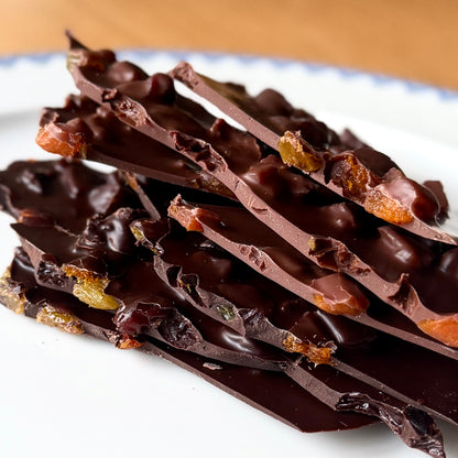 Dark chocolate bark with pieces of apricot on a white plate