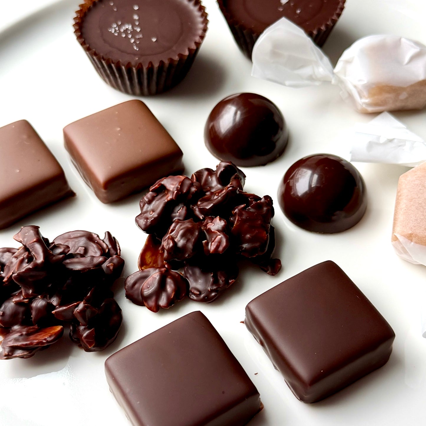 Assorted chocolate candies on a white surface
