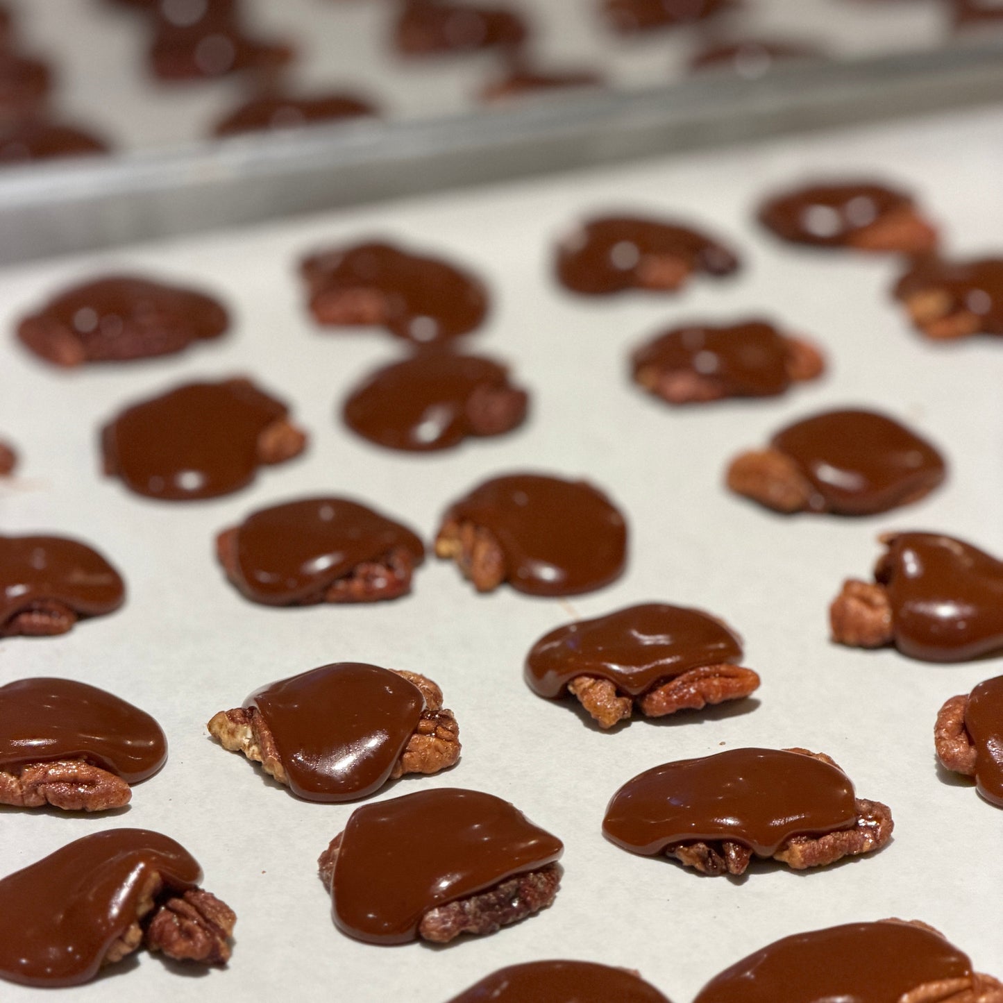 pecans covered with caramel in clusters on parchment