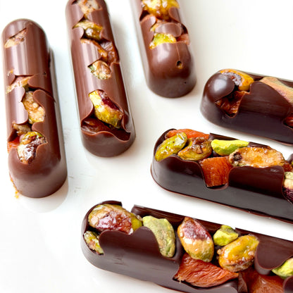 Chocolate-dipped treats with nuts on a white surface