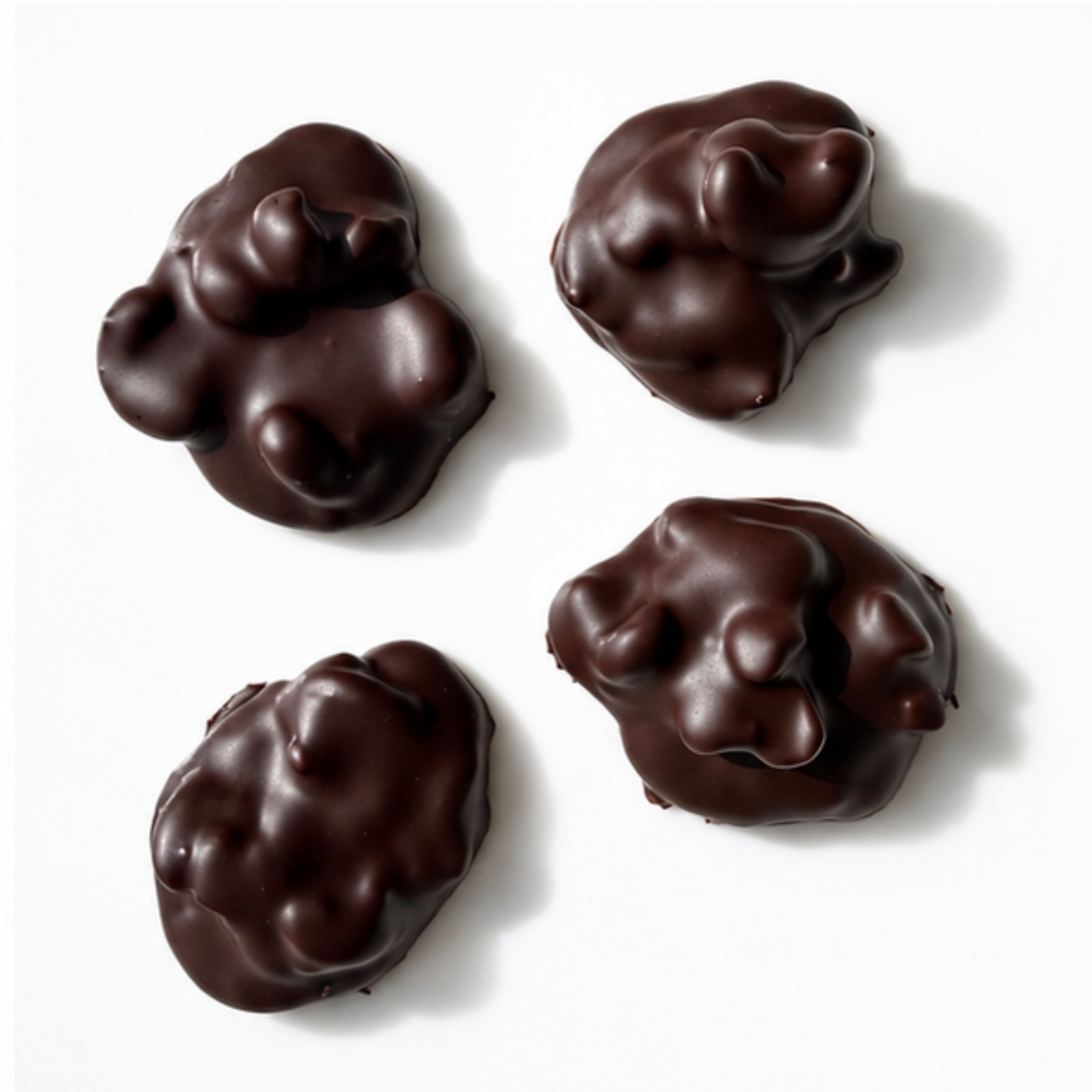 4 pieces of chocolate mounds with nuts on white background