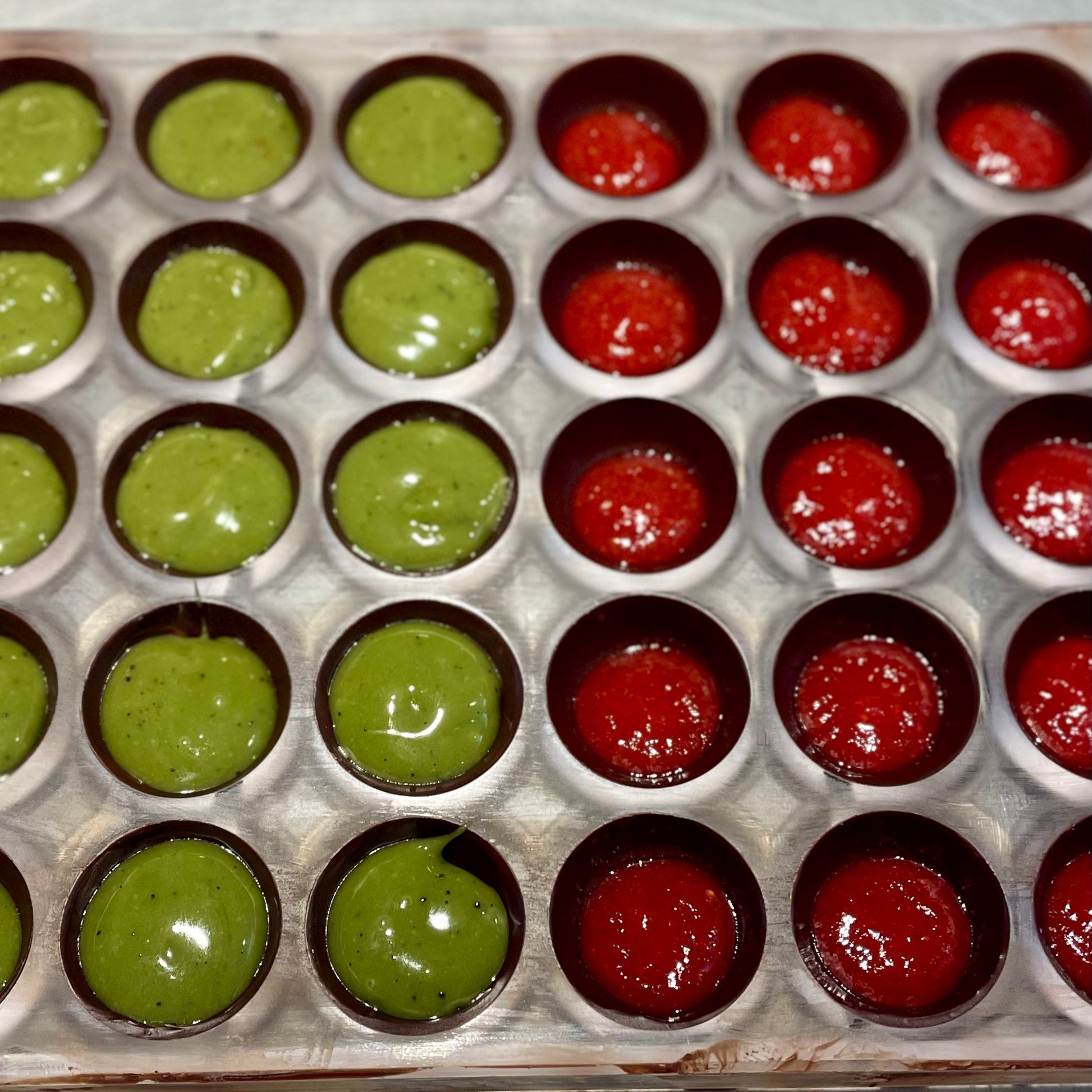 half dome mold filled with strawberry red pate de fruit and green matcha ganache