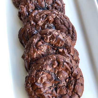 Dark Chocolate cookies overlapping in single line on white plate