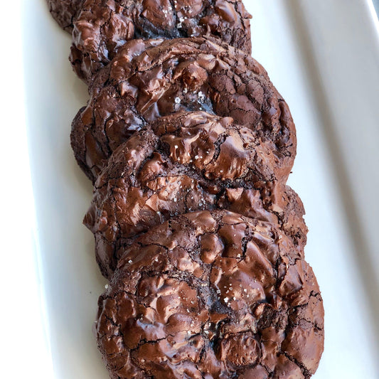Dark Chocolate cookies overlapping in single line on white plate