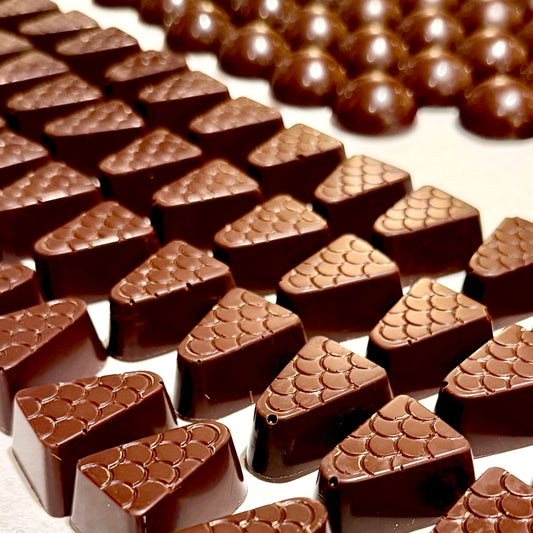 Close-up of triangular chocolate candies on a white background