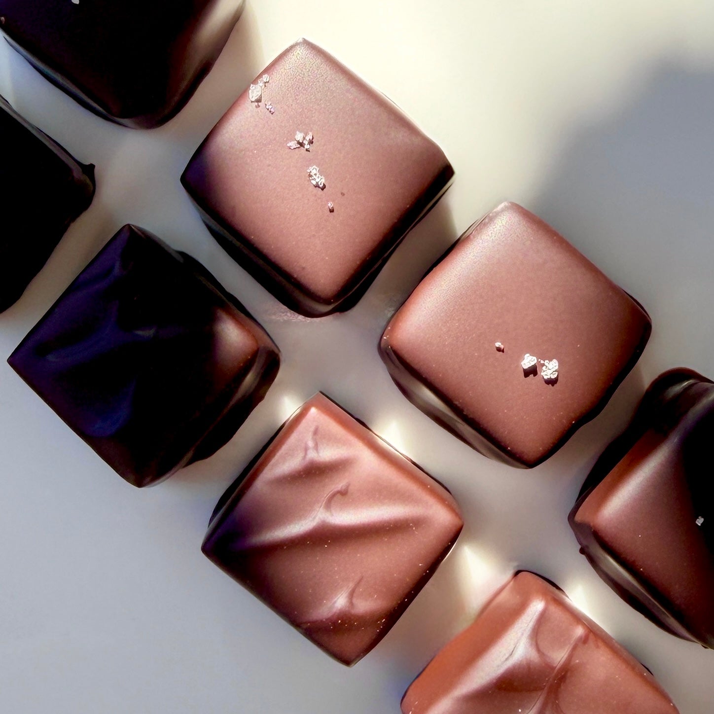 Assorted chocolate candies on a light background