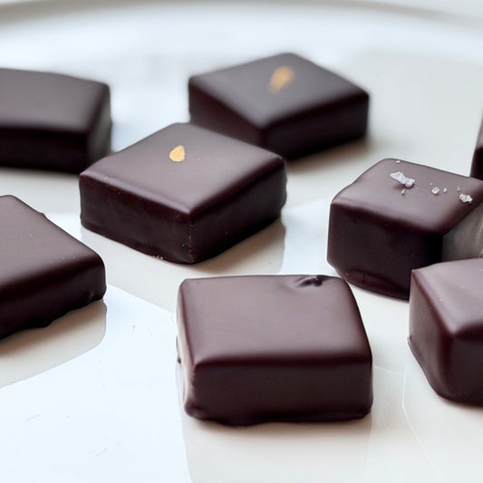 Dark chocolate candies on a white surface