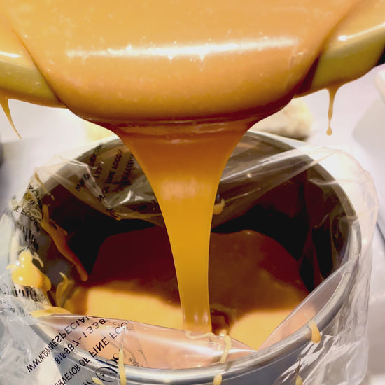 salted caramel ganache being poured from bowl into piping bag