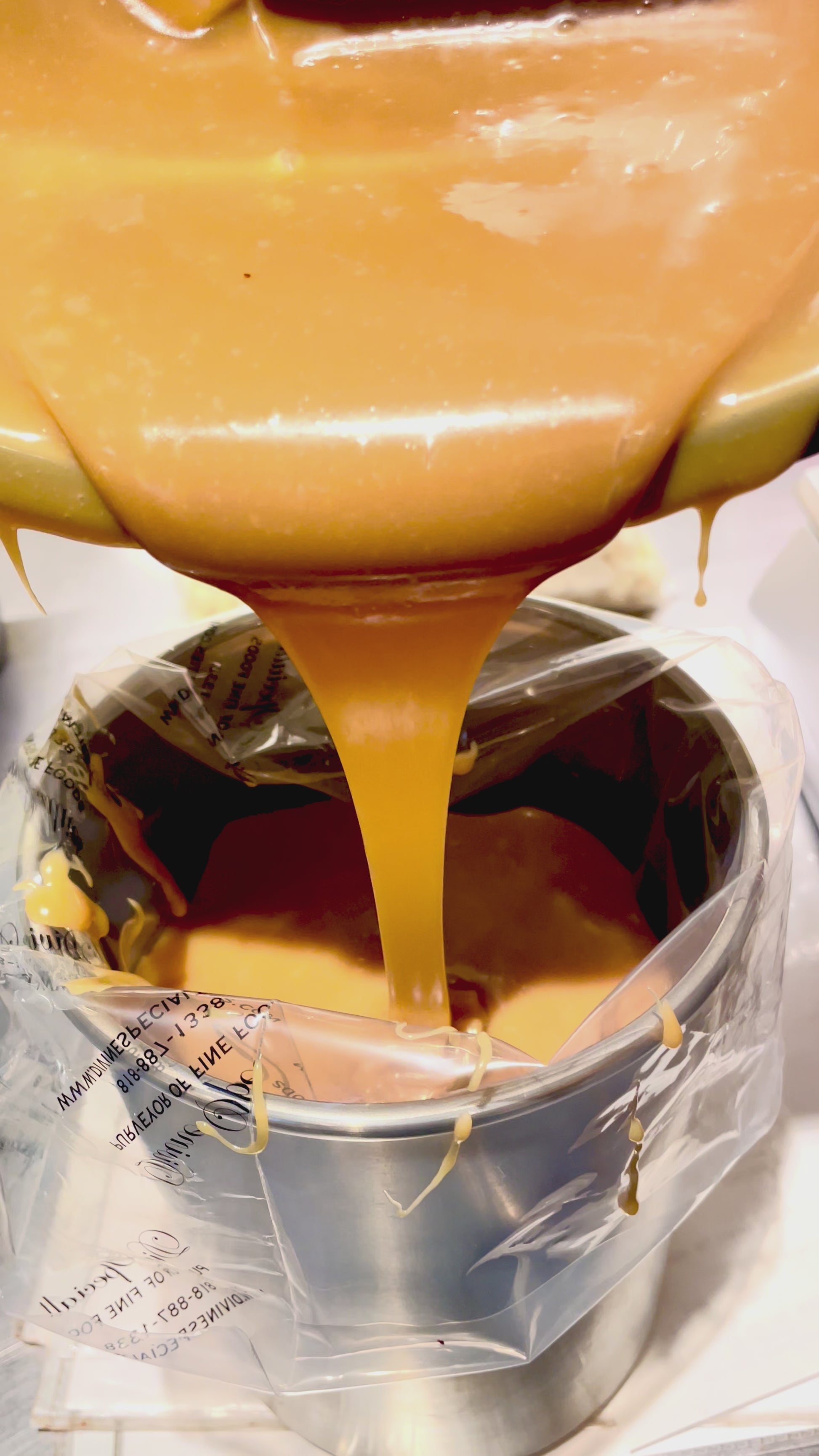 salted caramel ganache being poured from bowl into piping bag